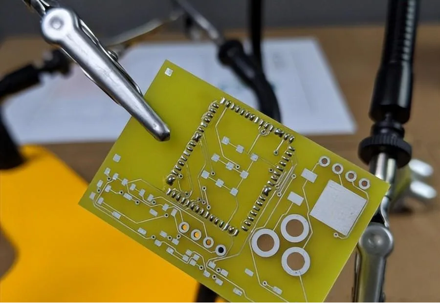 a prototype circuit board held in place for soldering.