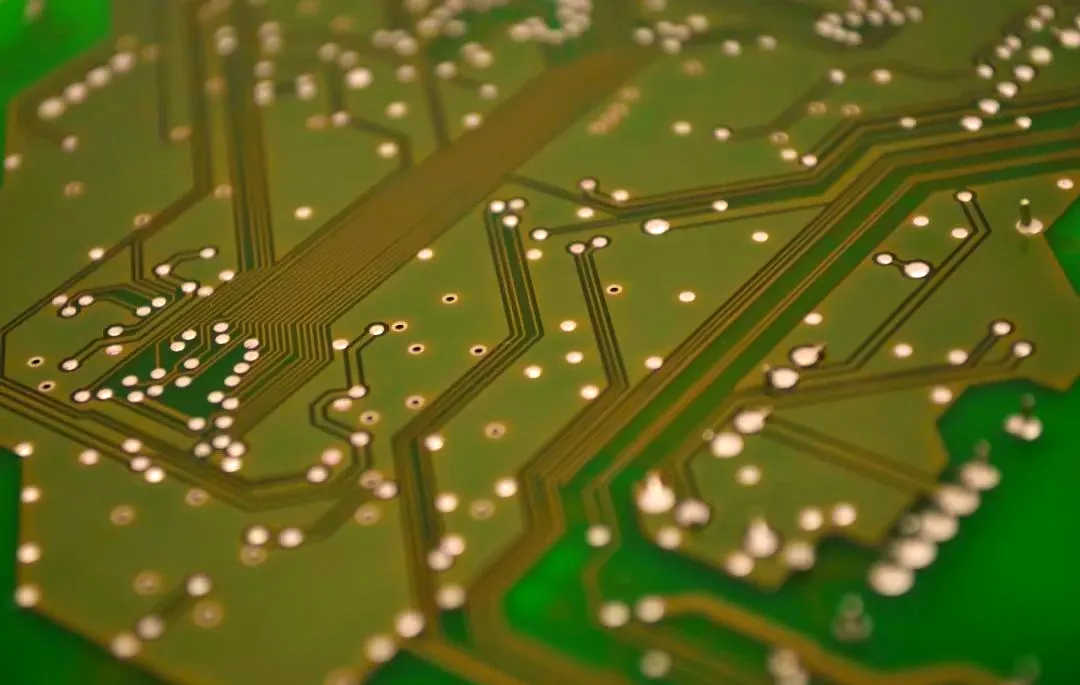 green circuit board with copper traces and solder
