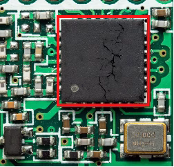 an SMT IC on a PCB with a red box highlighting visible surface cracks