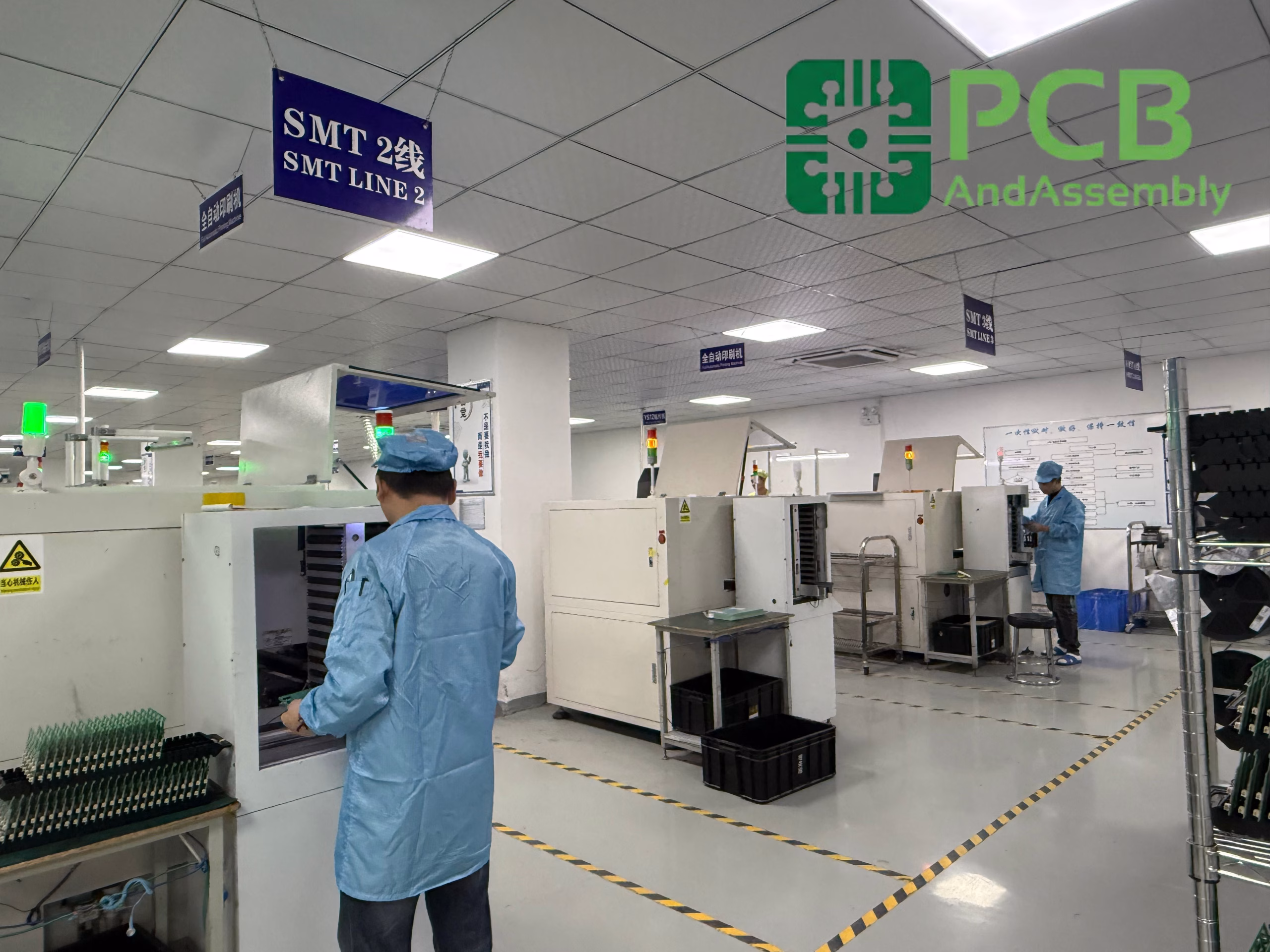 Electronics manufacturing floor with workers in blue cleanroom suits operating SMT machinery